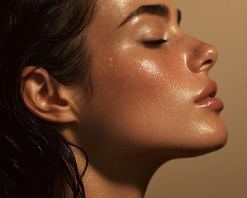 Side profile of a tanned model with glowing, wet skin against a beige background.